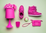 pink shoes and props arranged on green background